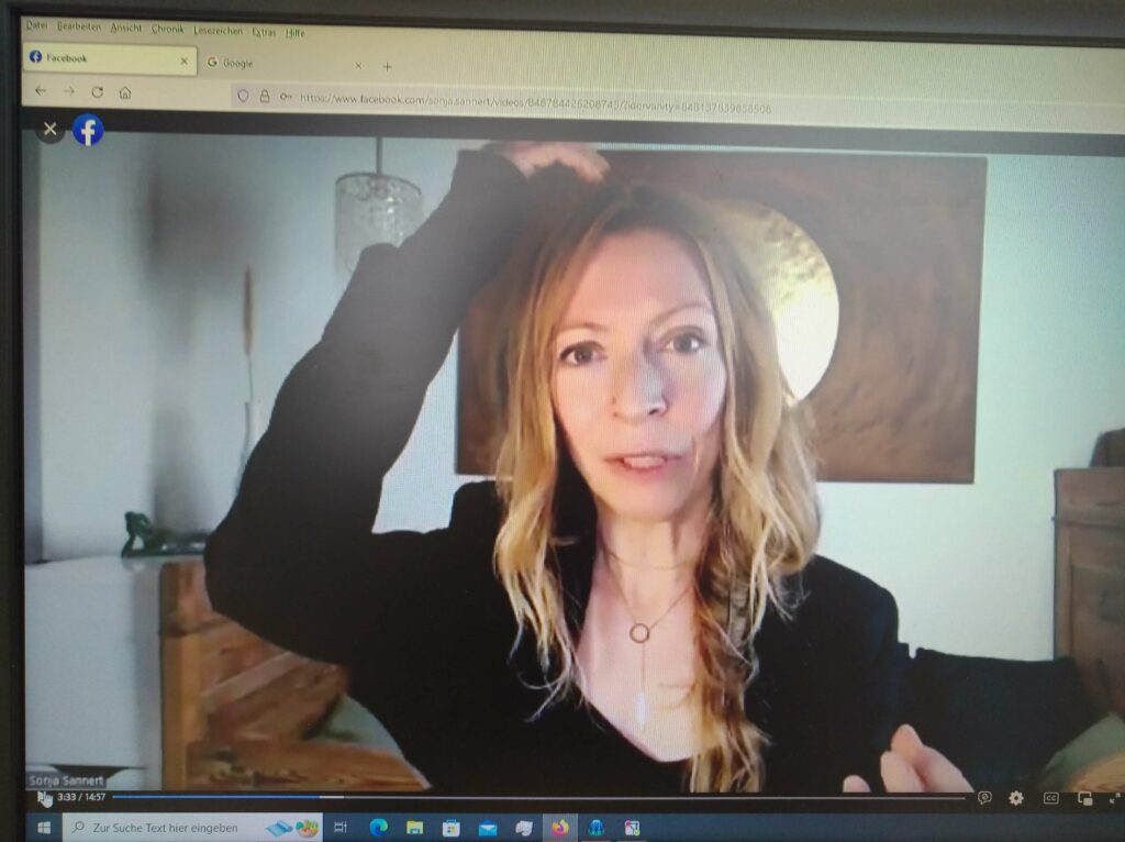 Screenshot, zu sehen ist eine Frau mit blonden Haaren und einem Seitenzopf, die sich mit den Fingern auf die Krone des Kopfes kloopft, EFT