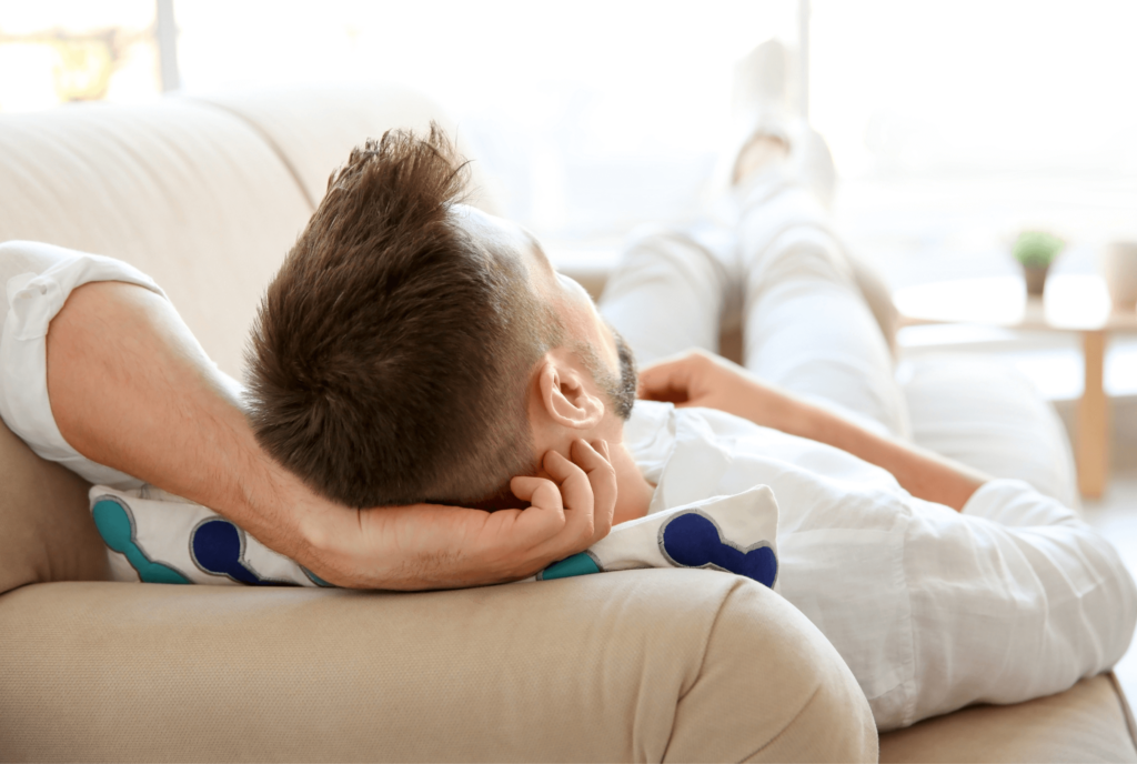 Ein mann liegt auf einem Sofa und genießt eine Fernreiki Session