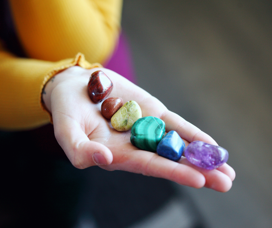 Edelsteine in den Farben der Chakren in einer Hand