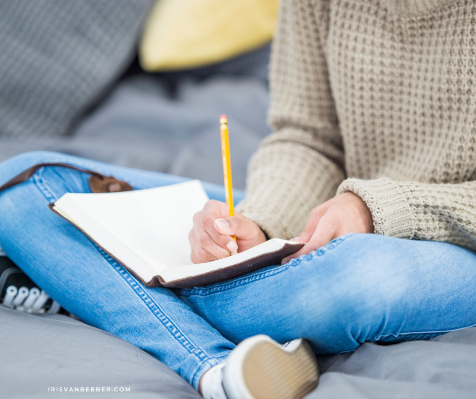 eine Frau in Jeans sitzt auf einer Couch zum Journaling oder Tagebuchschreiben