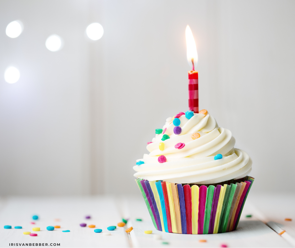 Ein Geburtstags-Muffion mit einer Kerze und bunten Streuseln